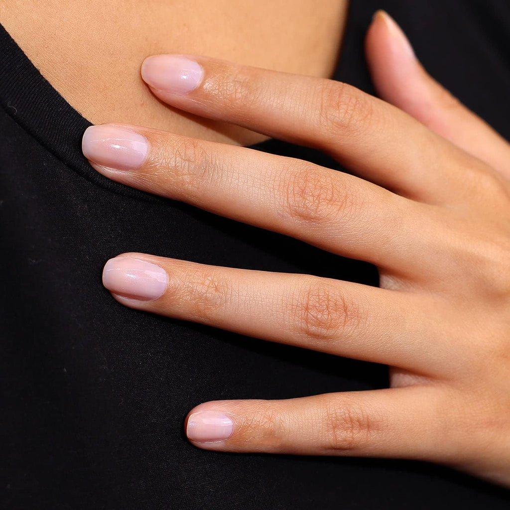Skaistums Švytintis Maskuoklis applied on nails with a soft pink finish, enhancing their natural look.